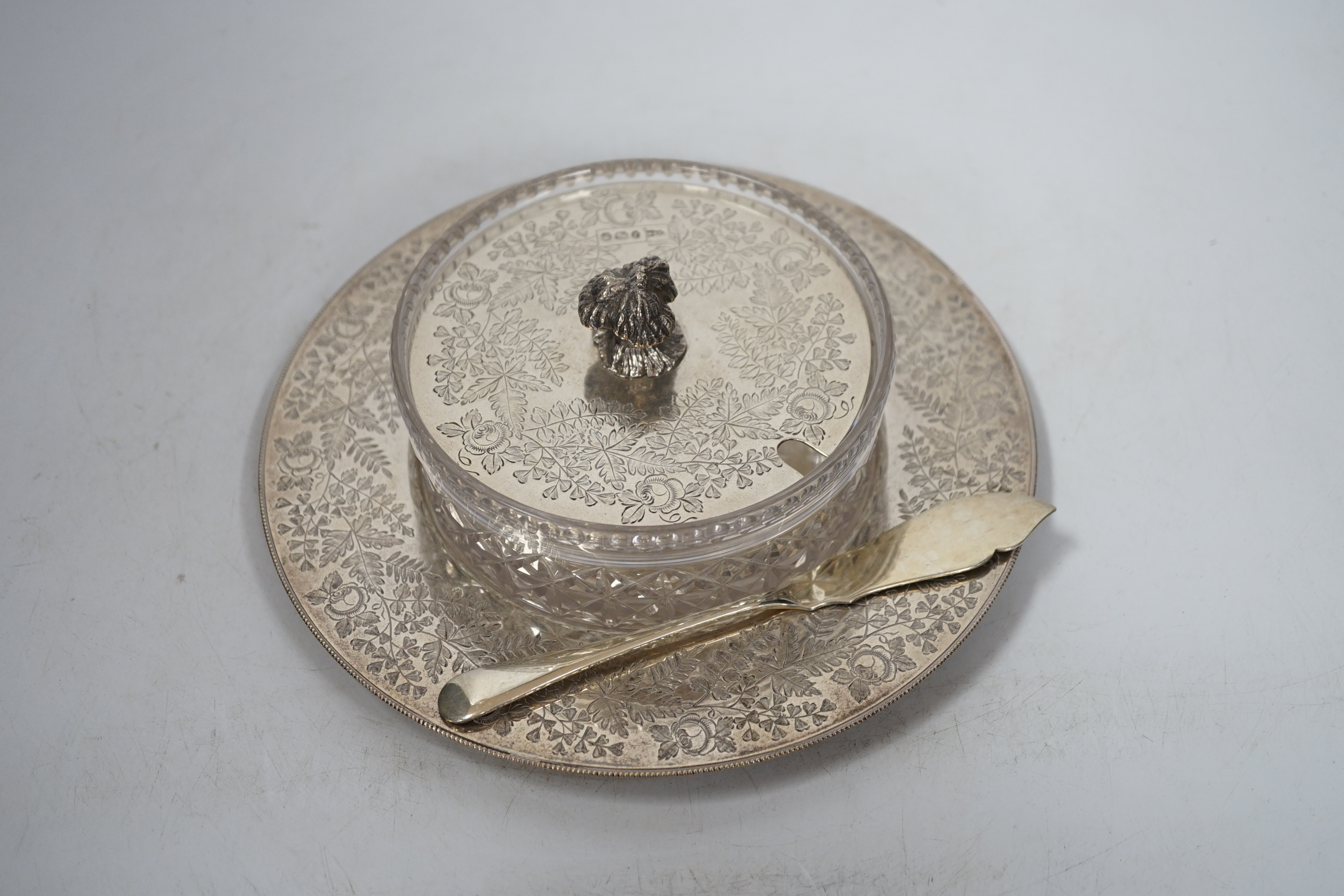 An Edwardian silver and glass butter dish, with engraved fern and rose decoration, Sheffield 1909, 428 grams of weighable silver, with an associated butter knife, 26 grams